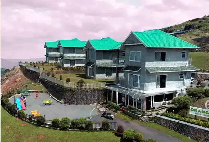 Exterior view of Orange Valley Hills Resort building with private balconies overlooking misty green hills