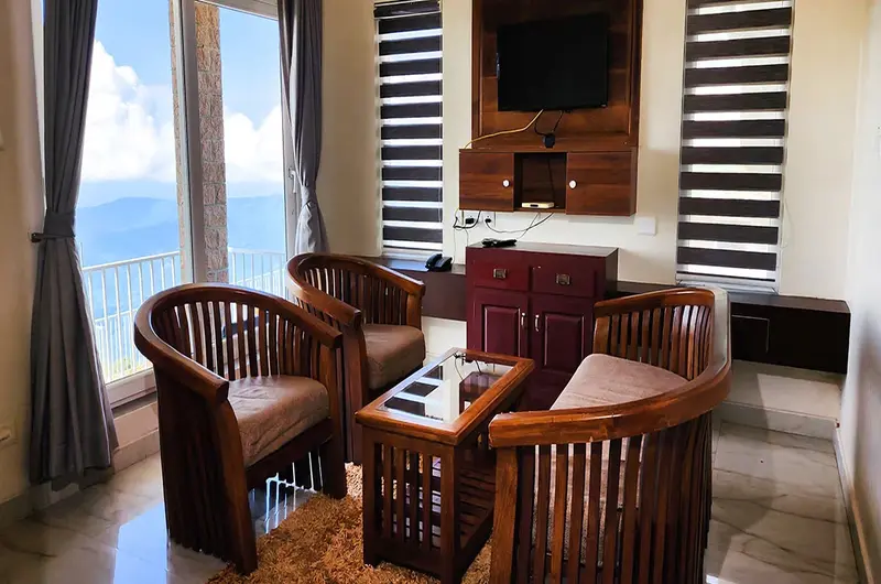 Cozy indoor seating area with wooden furniture and scenic valley views at Orange Valley Hills Resort