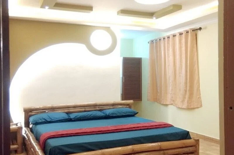 Deluxe guest bedroom suite with modern illuminated wall arch, ceiling lighting, and comfortable bedding