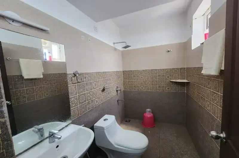 Ensuite guest bathroom with modern features and tiled interior at Wood Castle Residency Vagamon