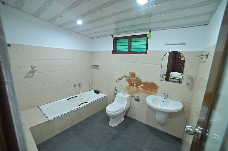 Spacious attached washroom with modern amenities and tile finish at Wood Castle Residency