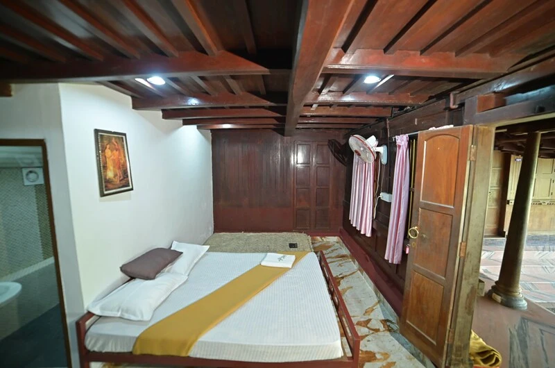 Well-lit resort guest bedroom with attached modern amenities at Wood Castle Residency