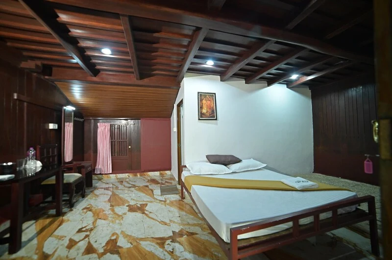 Cozy deluxe bedroom suite featuring modern wall lighting and plush bedding at Wood Castle Residency