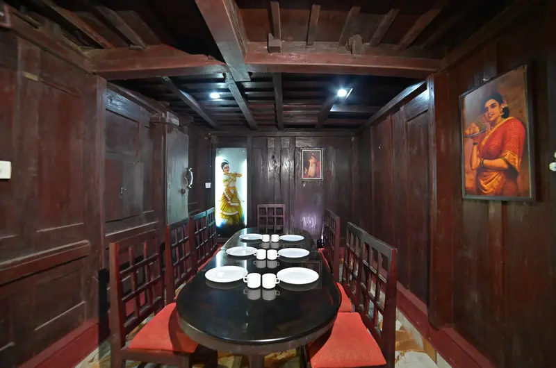 Rich wooden interior dining hall with traditional decor and warm lighting at Wood Castle Residency