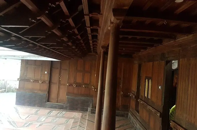 Traditional wooden veranda and pillar architecture offering scenic views at Wood Castle Residency
