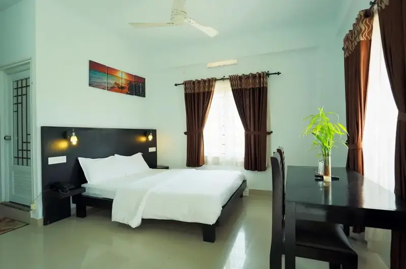 Deluxe resort guest bedroom featuring wooden double bed, sleek lighting fixtures, and modern decor