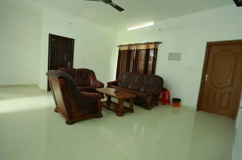 Cozy hotel lounge with wooden furniture, plush armchair seating, and tiled floor decor