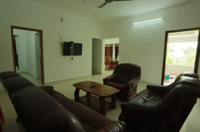 Spacious guest suite living area featuring comfortable dark leather armchairs and modern lighting