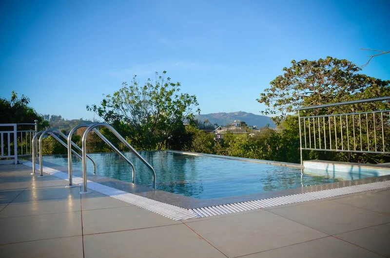 Outdoor swimming pool at Chillax Hotel overlooking scenic valley and mountain views in Vagamon