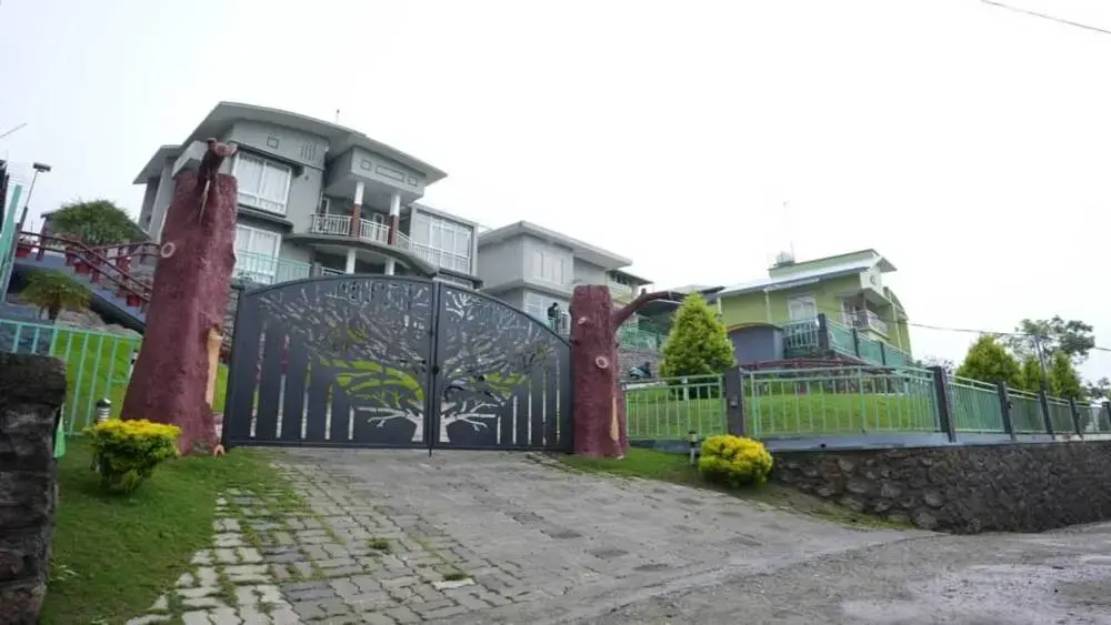Front entrance gate and paved driveway leading into Vaga Mist Resort property
