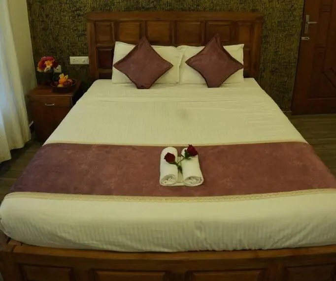 Deluxe resort guest bedroom featuring a king-size double bed with warm accent lighting