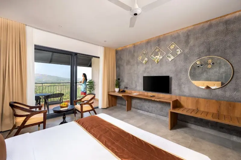 Spacious guest suite bedroom with double bed setup, wall mirror, work desk, and seating nook
