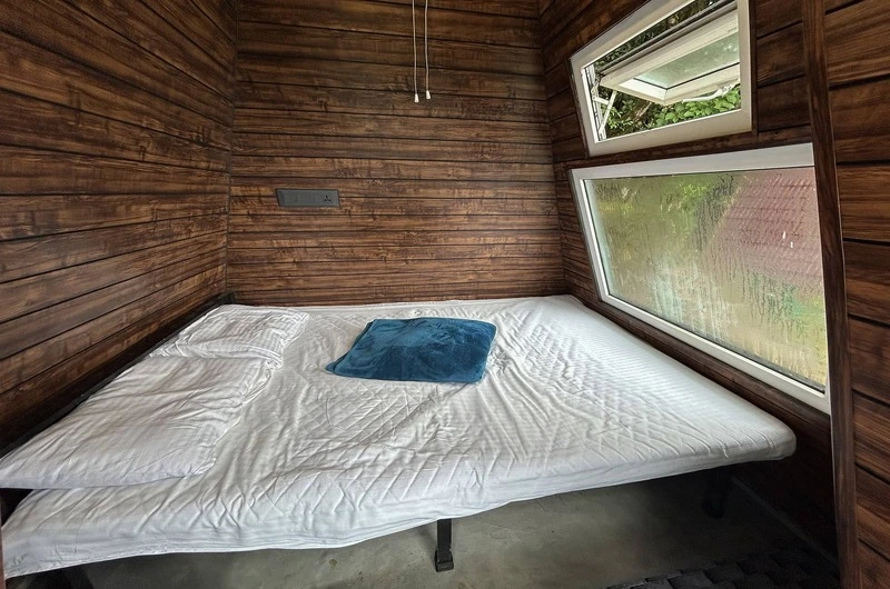 Spacious wooden cottage bedroom interior featuring double bed and polished timber walls