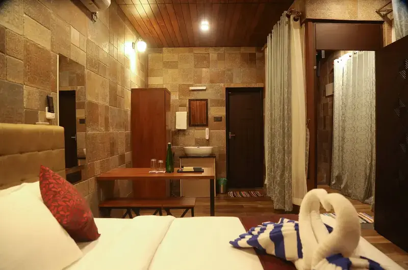 Luxury wooden cottage room with plush double bed, bedside table, and ambient lighting at Cloud Cabana Holidays