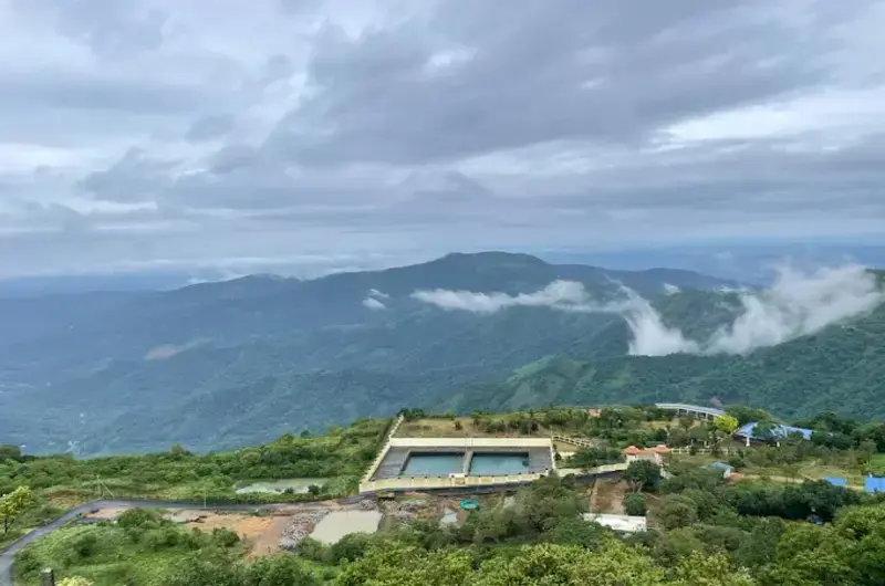 Panoramic view of misty green mountain valleys from private balcony deck at Cloud Cabana Holidays