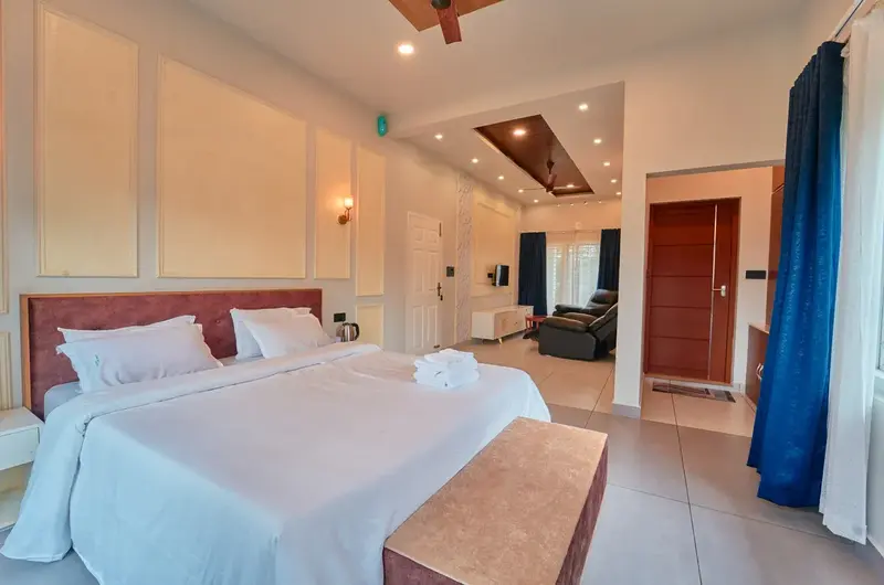 Deluxe double bedroom interior with crisp white linen at Choice Holidays Resort Vagamon.