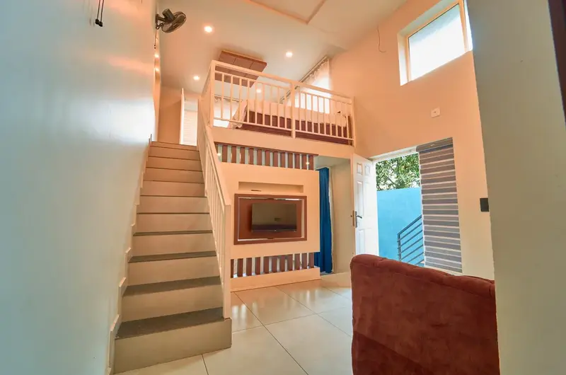 Modern duplex villa interior with wooden staircase at Choice Holidays Resort Vagamon.