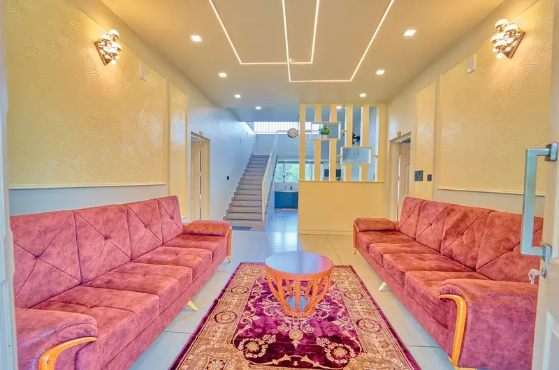 Luxurious villa living room with premium red sofa set and warm lighting at Choice Holidays Resort Vagamon.