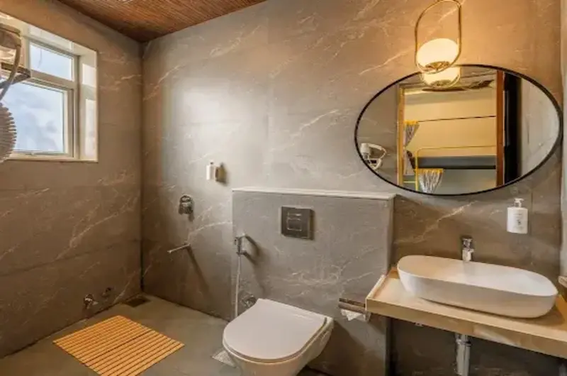 Premium suite bathroom featuring a stylish backlit mirror and vessel sink at The Hosteller Bam Vagamon.
