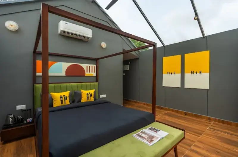 Modern premium bedroom interior with a four-poster bed and glass roof at The Hosteller Bam Vagamon.