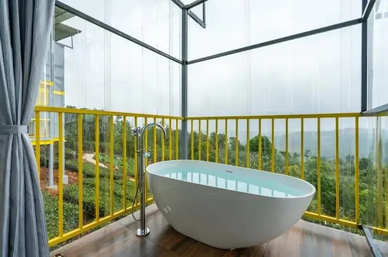 Private open-air balcony bathtub with scenic nature views at The Hosteller Bam Vagamon.