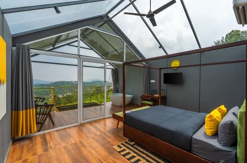 Glass-walled premium cabin suite with mountain views at The Hosteller Bam Vagamon.