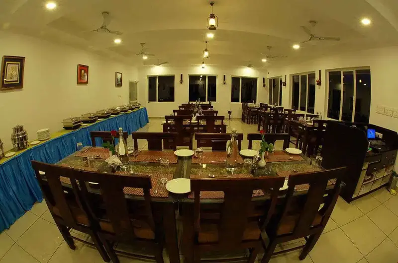 In-house restaurant dining hall setup with long wooden tables at The Grasmere Resort Vagamon.