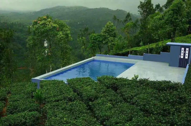 Luxury resort pool area with scenic mountain valley views in Vagamon.