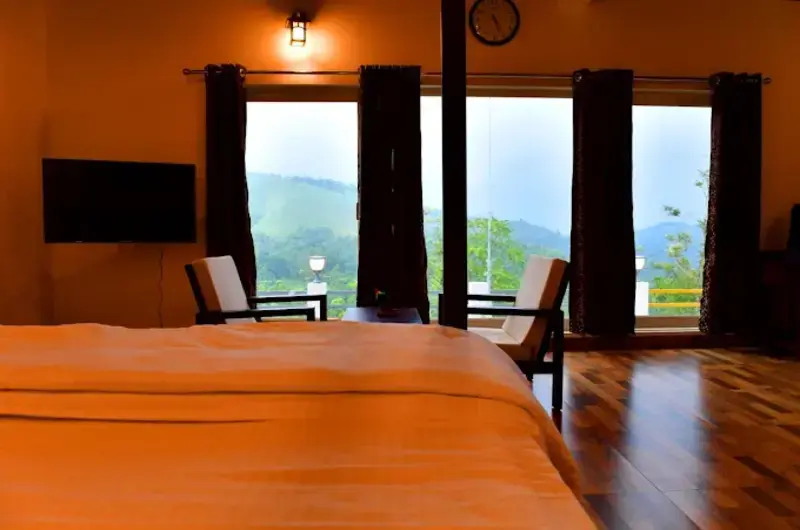 Scenic valley and mist view captured from the wooden balcony of a bedroom at Heaven Valley Resorts Vagamon.