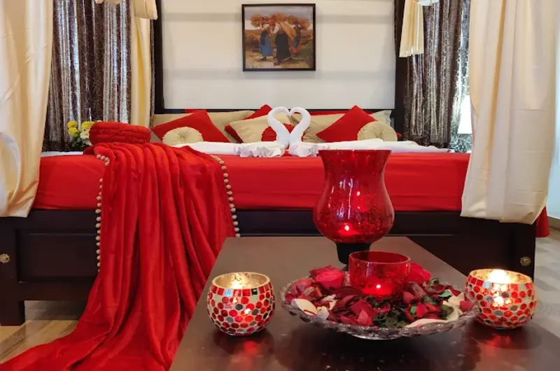 Luxury bedroom interior at Heaven Valley Resorts Vagamon featuring a beautifully decorated bed with red flower petals.