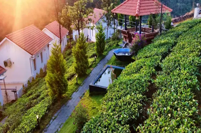 Scenic view of red-roofed hillside cottages and tea plantations at Heaven Valley Resorts Vagamon.