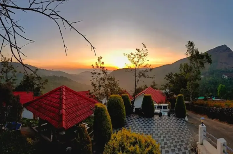 Beautiful sunset view overlooking the red-roofed cottages and misty hills at Heaven Valley Resorts Vagamon.