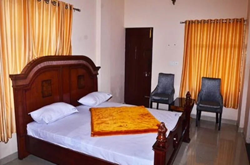 Executive hotel room featuring a rich dark wood bed frame, seating area, and warm interior lighting