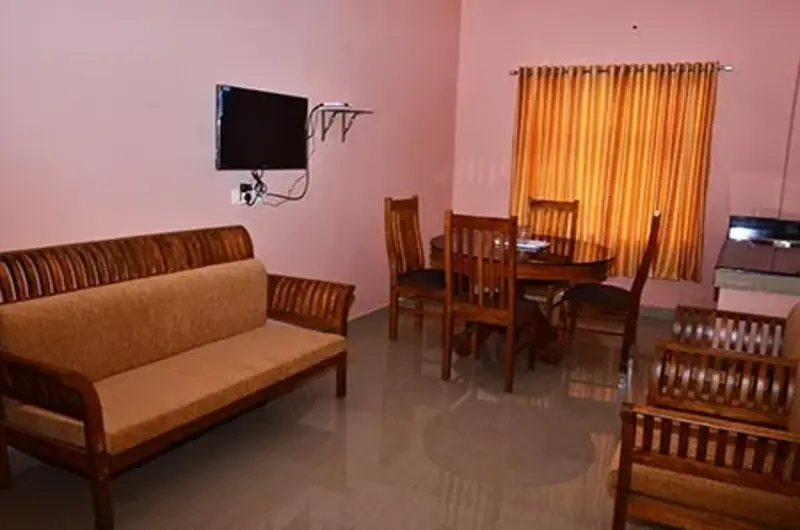 Spacious guest suite living hall featuring comfortable sofas, wall-mounted TV, and bright interior decor