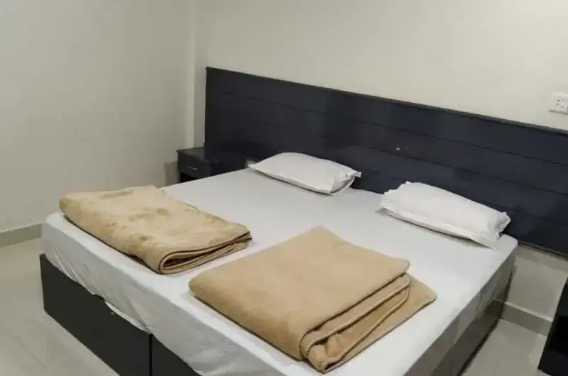 Spacious guest bedroom with multiple comfortable beds and clean bedding at Padmalayam Homestay