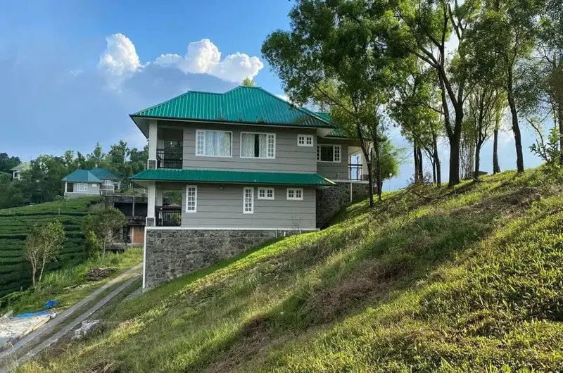 Two-story hillside cottage structure surrounded by tea plantations at Orion County Vagamon