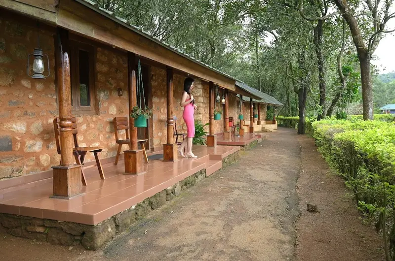 Paved stone pathway running alongside mud-brick cottage rooms at SAJ Vagamon Hideout