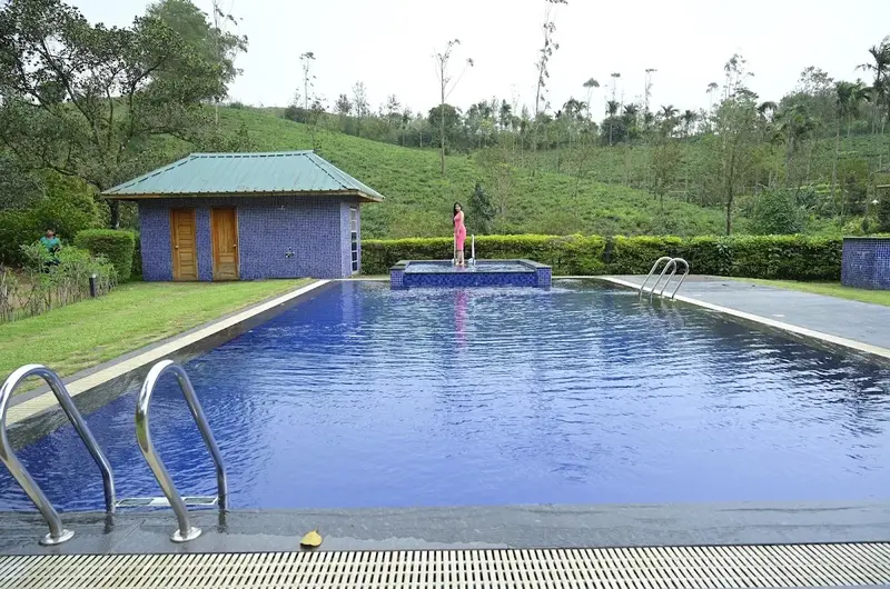 Eco-friendly swimming pool overlooking tea plantations and mountain ridges at SAJ Vagamon Hideout