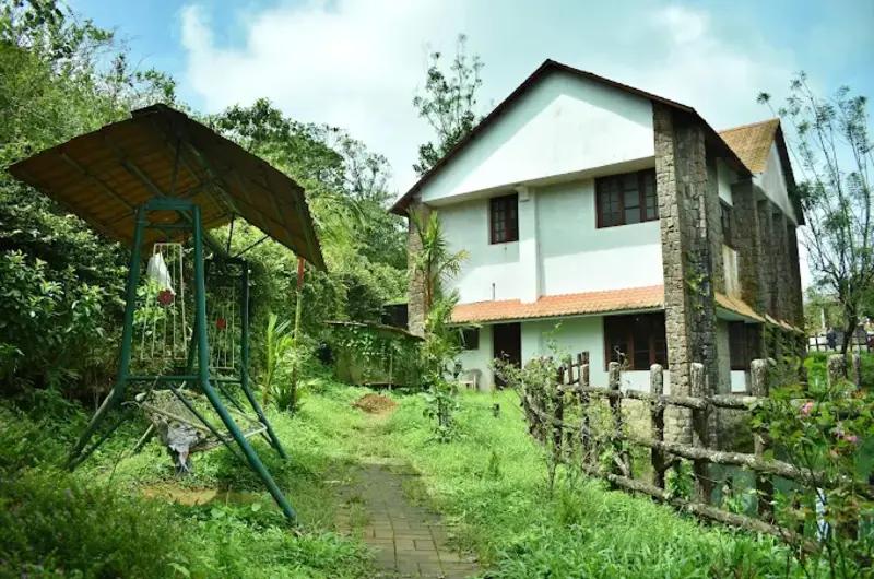 Traditional eco-heritage cottage exterior with stone masonry and red tile roof at Adrak Summer Sand Hill Resort Vagamon