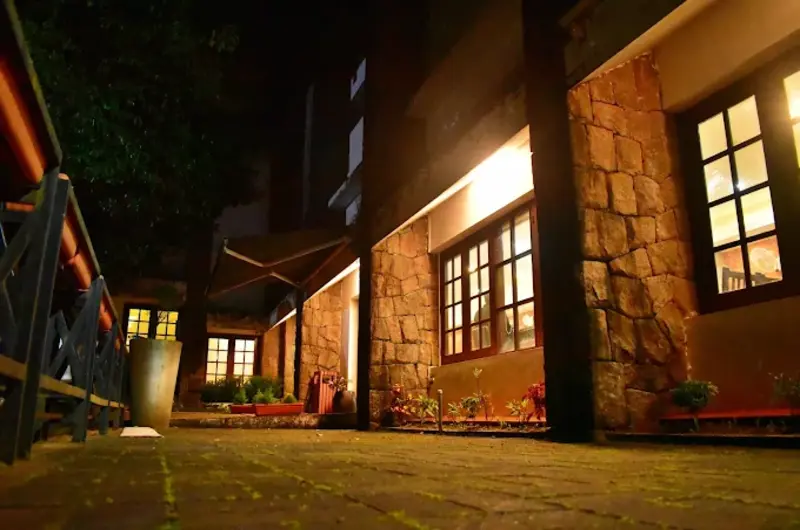 Cozy stone cottage exterior illuminated with warm night lighting at Adrak Summer Sand Hill Resort Vagamon