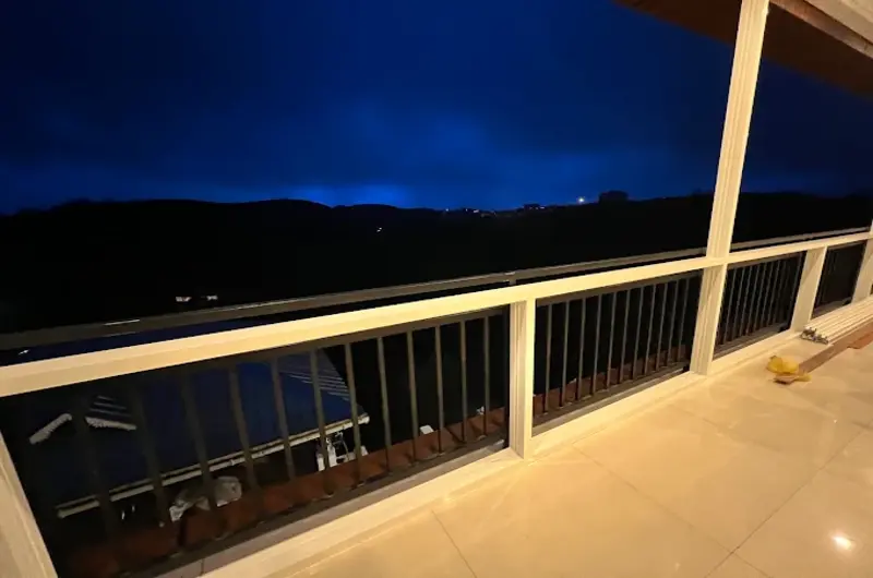 Night view from resort balcony deck with railing overlooking dusk sky at Moon Palace Kuttikanam