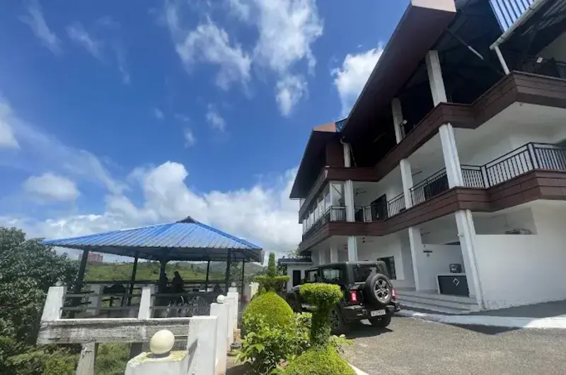 Front entrance facade of Moon Palace Kuttikanam with landscaped lawn and outdoor seating