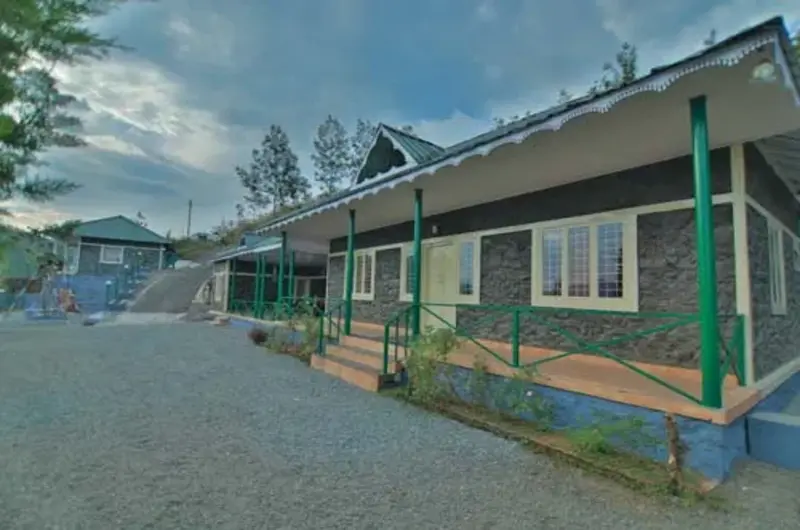 Exterior view of single-story Himaharsham Homestay building with verandah porch and paved yard in Vagamon
