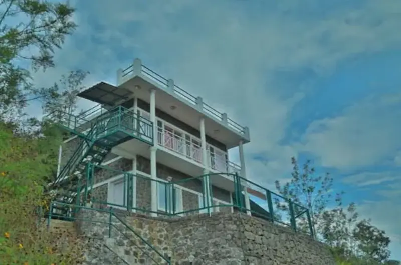 Modern multi-level hill cottage structure with glass balcony deck overlooking mountains at Himaharsham Homestay Vagamon