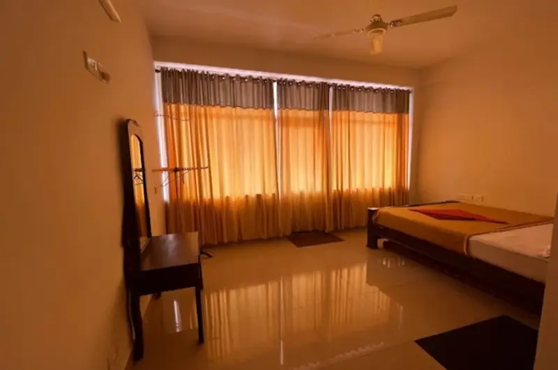 Spacious family suite bedroom featuring multiple double beds and warm ambient lighting