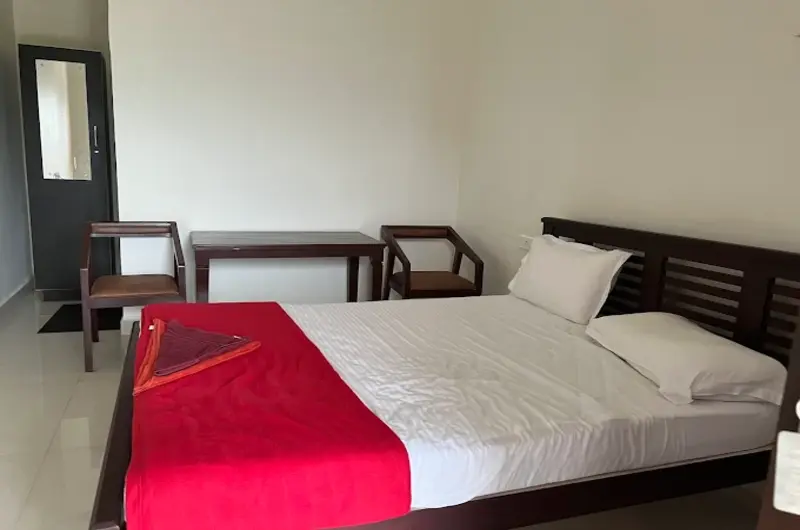 Modern guest bedroom featuring a king bed with red throw blanket and bedside furniture