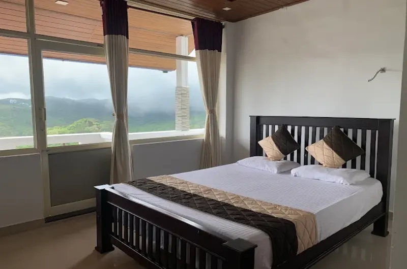 Deluxe bedroom suite featuring large windows with mountain views and dark wood furniture