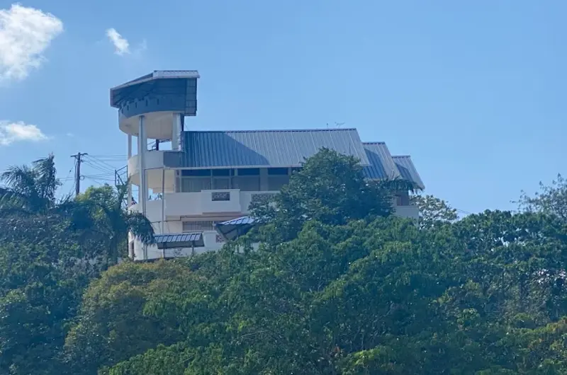 Exterior view of Moon Palace Hillstay building set amidst lush green hills in Vagamon