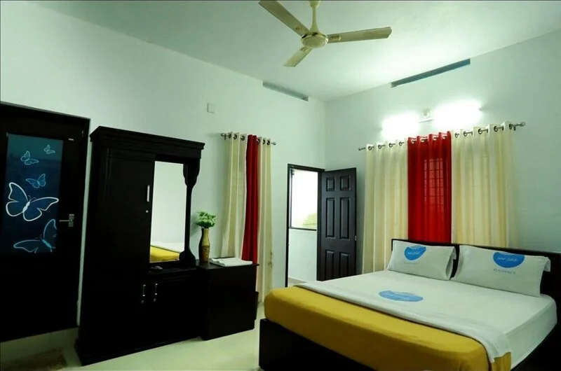 Spacious family guest room featuring double bed setup, wardrobe, and green accent wall decoration