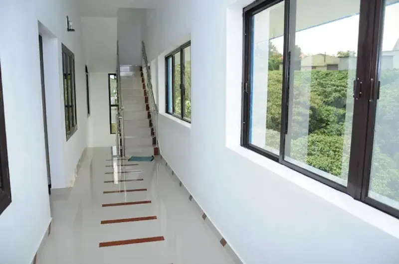 Clean tiled guest room corridor leading to rooms at Snow White Residency Vagamon